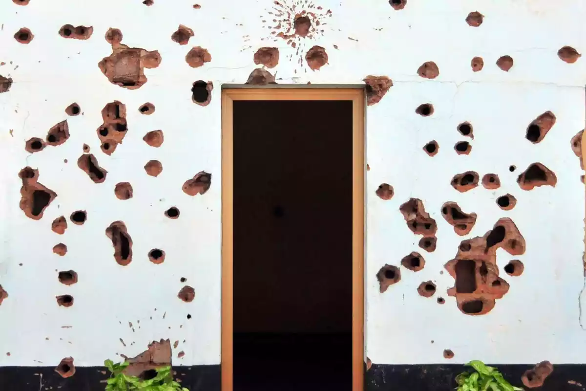 Casa con agujeros de bala en las paredes