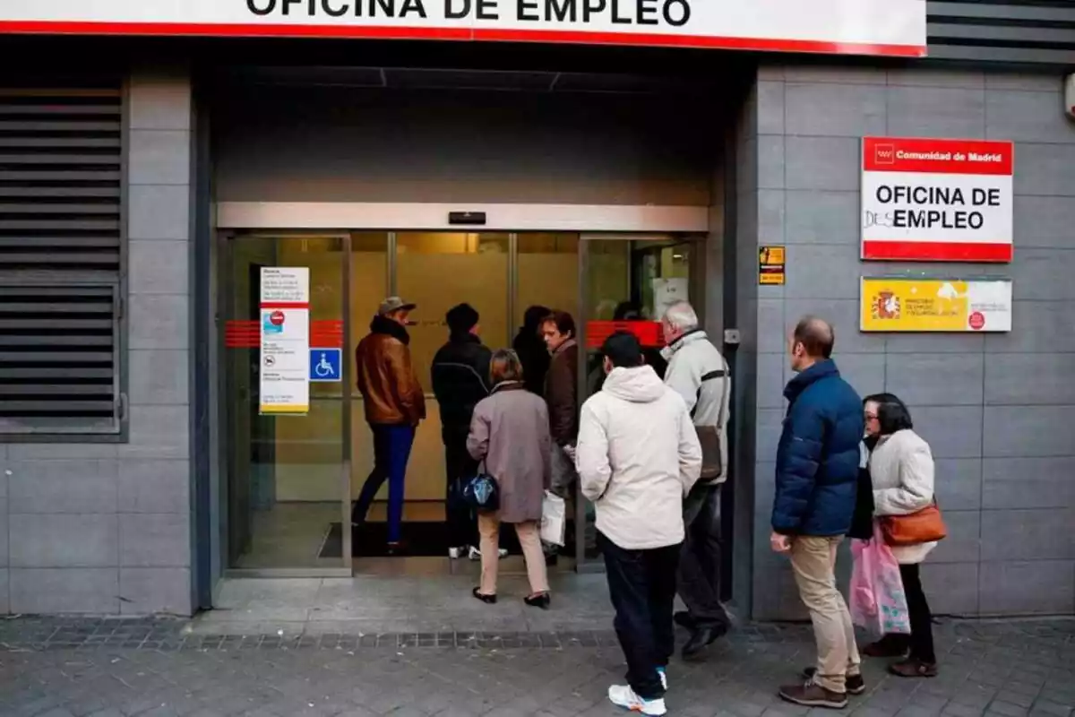 Diversas personas hacen cola para entrar a la oficina de empleo en la ciudad de Madrid