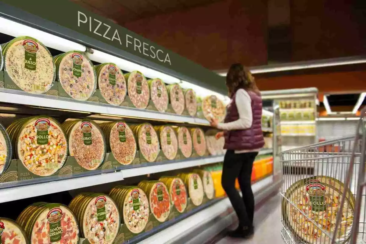 Imagen de una mujer en el pasillo de pizzas frescas. Todas son de marca Casa Tarradellas